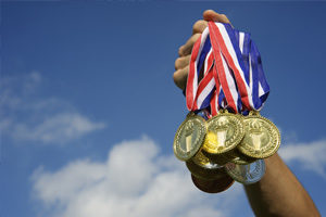 athlete-holding-medals-in-the-sky